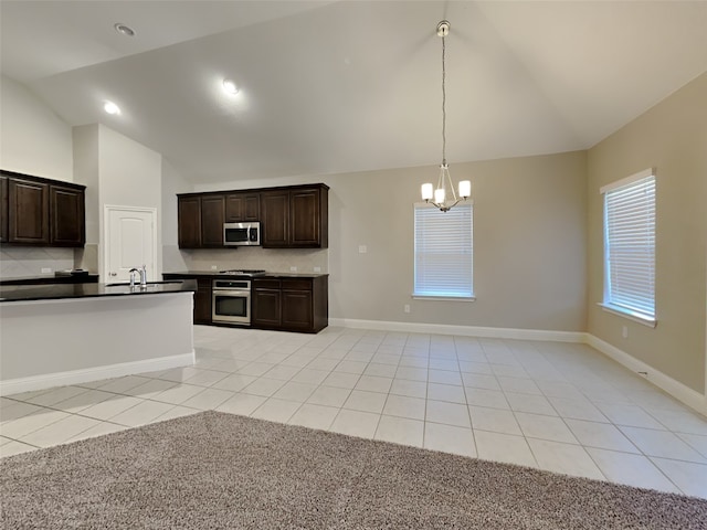 5116 Stockwhip Dr, Fort Worth, TX 76036 - kitchen featuring stainless steel appliances, dark countertops, light tile patterned floors, a chandelier, and high vaulted ceiling