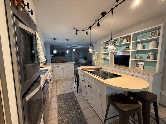 522 W 7th St, Weatherford, TX 76086 - kitchen with open floor plan, white cabinetry, a breakfast bar, black electric cooktop, and a peninsula