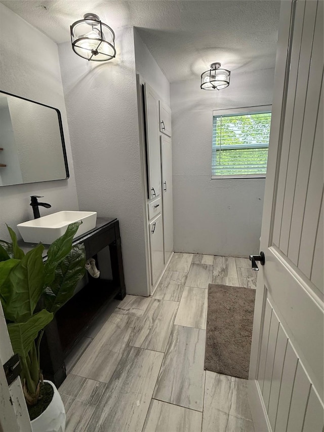 522 W 7th St, Weatherford, TX 76086 - bathroom with a sink, wood finish floors, and a textured ceiling