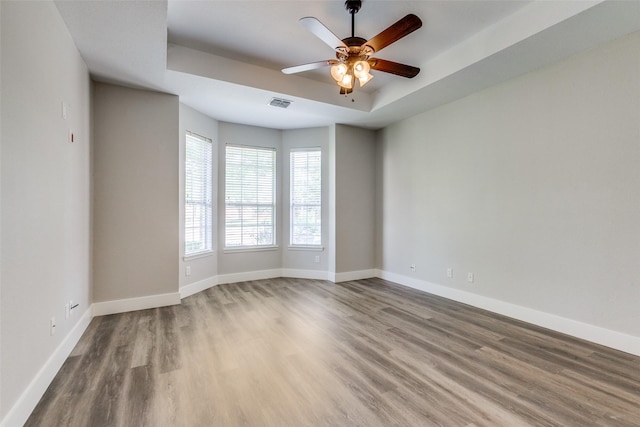 318 Mesquite Ct, Murphy, TX 75094 - spare room with wood finished floors, baseboards, a ceiling fan, and a tray ceiling