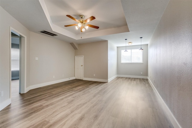 318 Mesquite Ct, Murphy, TX 75094 - unfurnished room with a tray ceiling, ceiling fan, wood finished floors, and baseboards