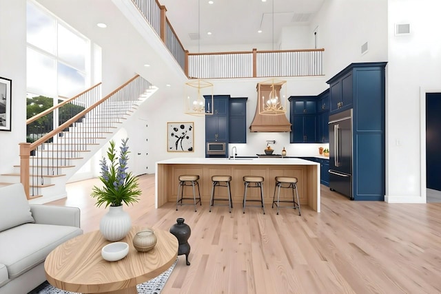 733 El Barco, Corsicana, TX 75109 - kitchen with blue cabinets, custom exhaust hood, a towering ceiling, built in appliances, and a sink