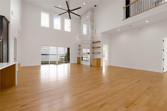 733 El Barco, Corsicana, TX 75109 - unfurnished living room with a towering ceiling, healthy amount of natural light, a ceiling fan, light wood finished floors, and recessed lighting