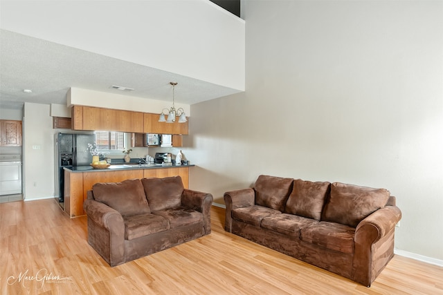 3636 Greenacres Place Dr Unit 33, Bossier City, LA 71111 - living area with baseboards, light wood finished floors, washer / dryer, and a chandelier