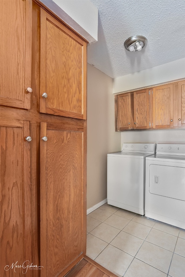 3636 Greenacres Place Dr Unit 33, Bossier City, LA 71111 - washroom featuring washer and dryer, cabinet space, a textured ceiling, baseboards, and light tile patterned floors