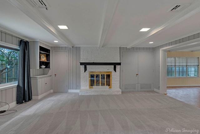 unfurnished living room featuring beamed ceiling, carpet floors, a fireplace, ornamental molding, and recessed lighting