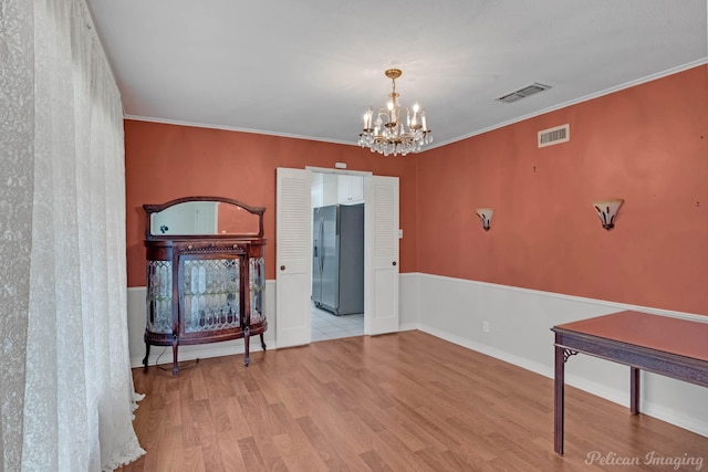unfurnished room featuring wood finished floors and a chandelier