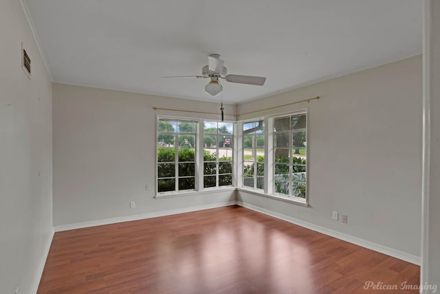 empty room featuring wood finished floors, ceiling fan, and baseboards