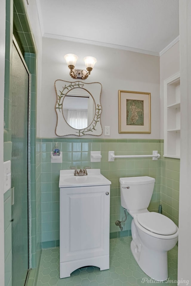 full bathroom featuring ornamental molding, vanity, a wainscoted wall, toilet, and a shower with door