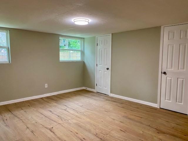 4916 Tracy Dr, Haltom City, TX 76117 - unfurnished bedroom with light wood-style flooring, baseboards, and multiple windows