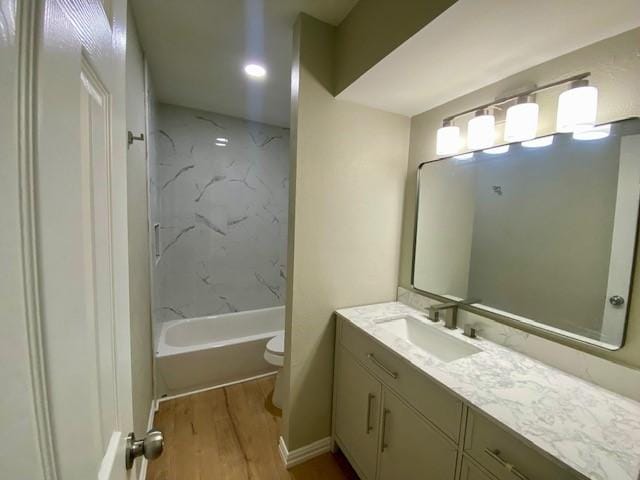 4916 Tracy Dr, Haltom City, TX 76117 - bathroom featuring vanity, toilet, wood finished floors, and bathtub / shower combination