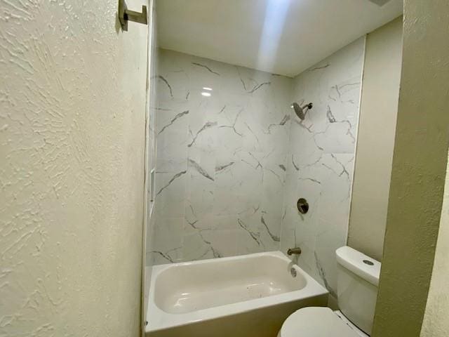 4916 Tracy Dr, Haltom City, TX 76117 - bathroom featuring toilet, a textured wall, and shower / washtub combination