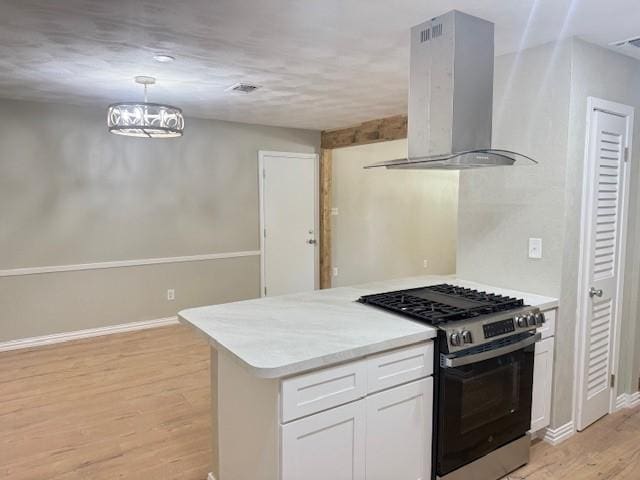 4916 Tracy Dr, Haltom City, TX 76117 - kitchen featuring exhaust hood, stainless steel gas range, white cabinetry, light wood-style flooring, and light countertops