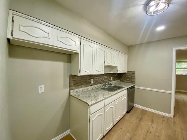 4916 Tracy Dr, Haltom City, TX 76117 - kitchen featuring a sink, stainless steel dishwasher, white cabinetry, decorative backsplash, and light wood-style floors
