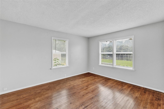 4208 Huckleberry Cir, Dallas, TX 75216 - spare room with hardwood / wood-style flooring, a textured ceiling, and baseboards