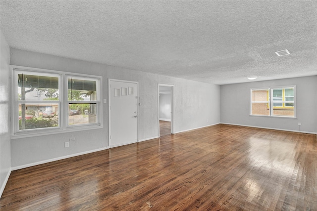 4208 Huckleberry Cir, Dallas, TX 75216 - unfurnished living room featuring a textured ceiling, wood finished floors, and baseboards