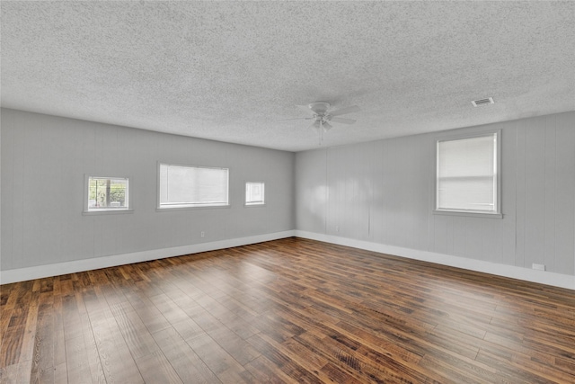 4208 Huckleberry Cir, Dallas, TX 75216 - spare room featuring dark wood-style flooring, ceiling fan, a textured ceiling, and baseboards