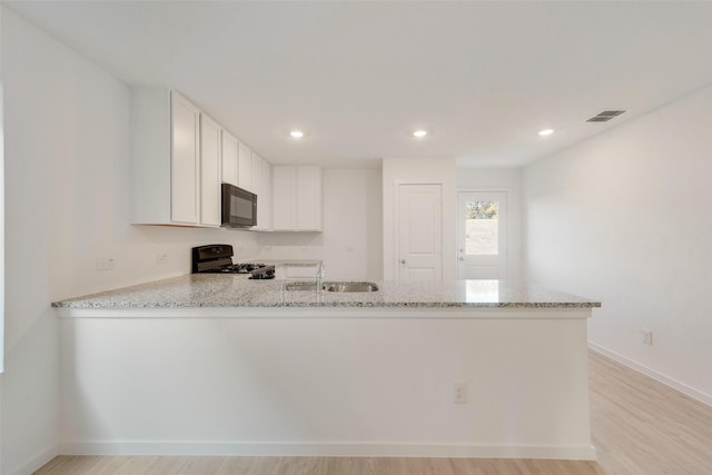 4213 Brindley Rd, Little Elm, TX 75068 - kitchen featuring black appliances, a sink, a peninsula, light stone counters, and light wood-style flooring
