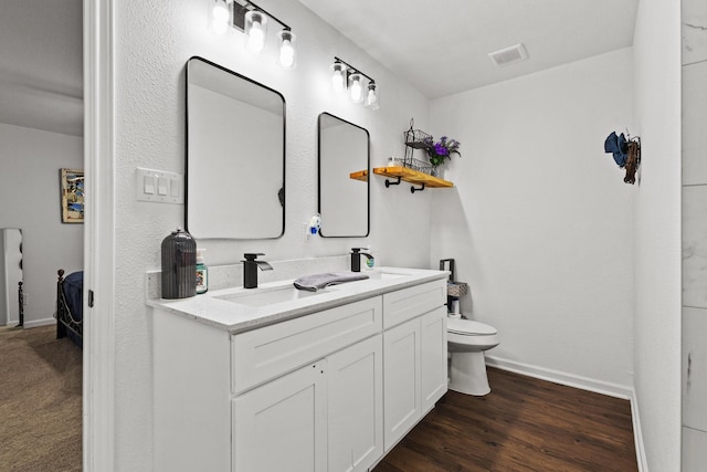 1807 W Belden St, Sherman, TX 75092 - ensuite bathroom with baseboards, toilet, double vanity, and wood finished floors