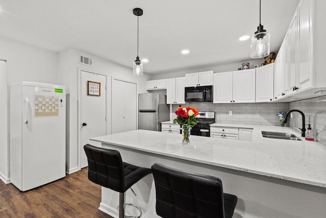 1807 W Belden St, Sherman, TX 75092 - kitchen with appliances with stainless steel finishes, a sink, a peninsula, white cabinets, and recessed lighting