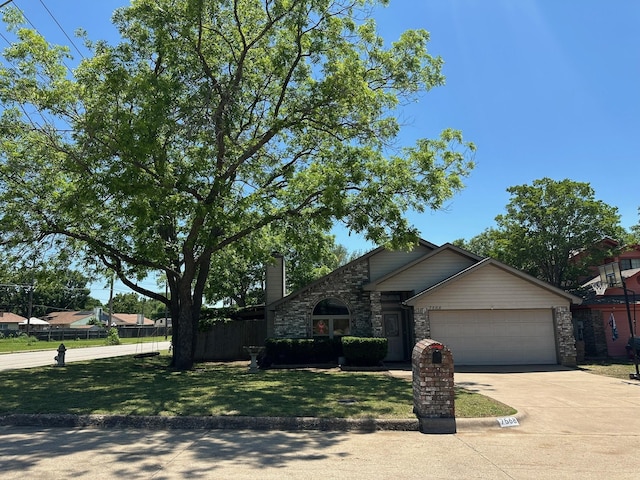 7568 Casburn Ct, Fort Worth, TX 76120 - view of front facade featuring an attached garage, driveway, and stone siding