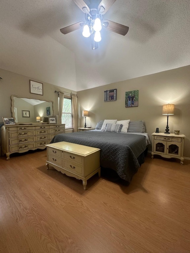 7568 Casburn Ct, Fort Worth, TX 76120 - bedroom featuring wood finished floors, lofted ceiling, a textured ceiling, and a ceiling fan