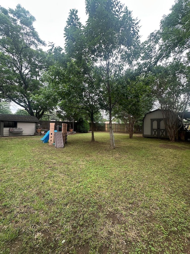 7568 Casburn Ct, Fort Worth, TX 76120 - view of yard featuring a playground, a storage unit, and an outdoor structure