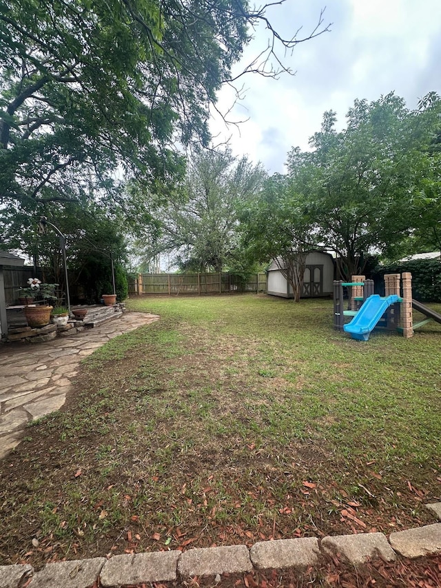 7568 Casburn Ct, Fort Worth, TX 76120 - view of yard with a storage shed, a playground, and an outbuilding
