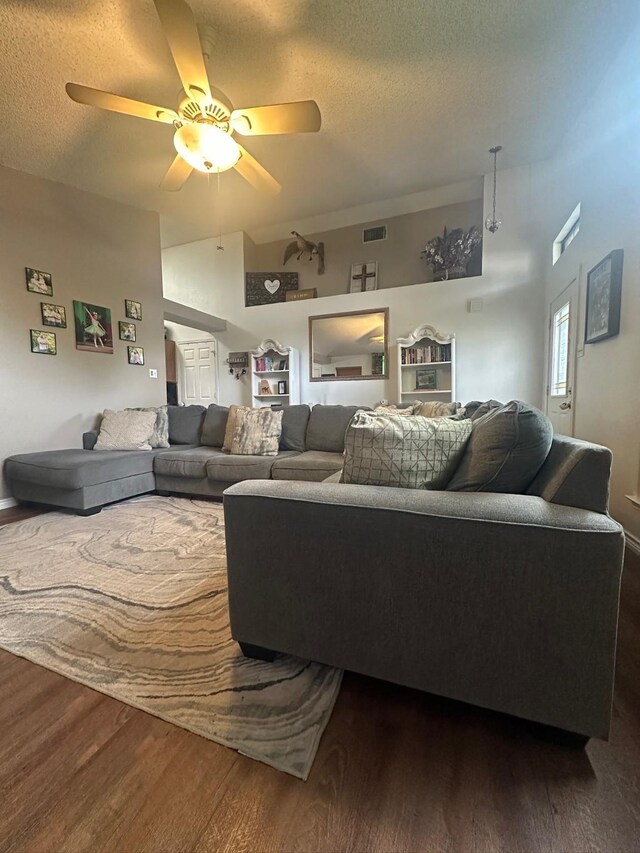 7568 Casburn Ct, Fort Worth, TX 76120 - living area featuring a textured ceiling, dark wood-style flooring, ceiling fan, and vaulted ceiling