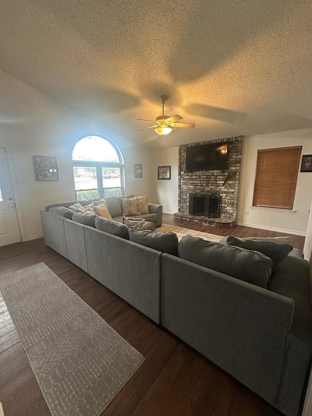 7568 Casburn Ct, Fort Worth, TX 76120 - living area with ceiling fan, a textured ceiling, wood finished floors, a large fireplace, and vaulted ceiling