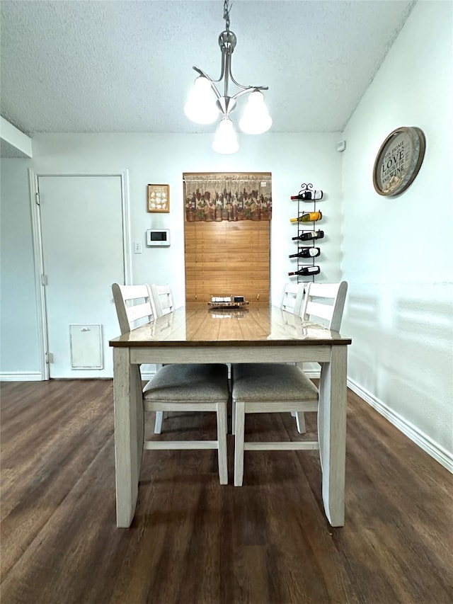 7568 Casburn Ct, Fort Worth, TX 76120 - dining area with a chandelier, a textured ceiling, wood finished floors, and baseboards