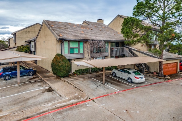 4559 N O Connor Rd Unit 2289, Irving, TX 75062 - view of front of house featuring covered and uncovered parking, stucco siding, and a chimney
