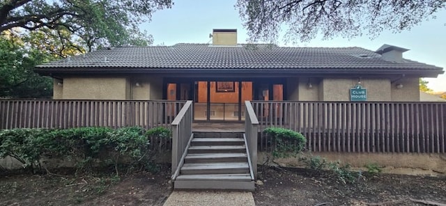 4559 N O Connor Rd Unit 2289, Irving, TX 75062 - view of front of property with a chimney, stucco siding, covered porch, a tile roof, and stairs