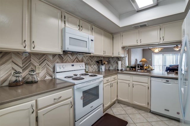 4559 N O Connor Rd Unit 2289, Irving, TX 75062 - kitchen featuring white appliances, a sink, light tile patterned floors, decorative backsplash, and white cabinetry