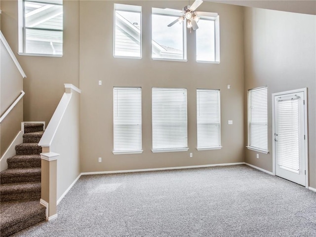 1341 Bristol Ln, Providence Village, TX 76227 - unfurnished living room with carpet floors, a towering ceiling, ceiling fan, and stairs