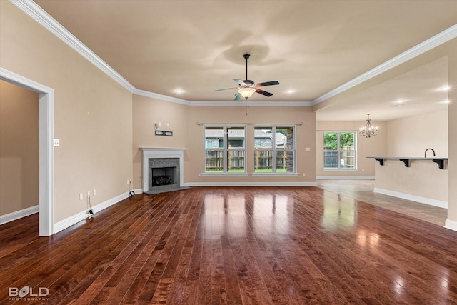 9214 Mykanos Trl, Shreveport, LA 71106 - unfurnished living room featuring dark wood-style floors, a chandelier, ornamental molding, ceiling fan, and a fireplace