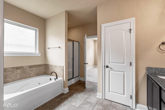 9214 Mykanos Trl, Shreveport, LA 71106 - bathroom featuring a stall shower, a jetted tub, vanity, tile patterned floors, and baseboards
