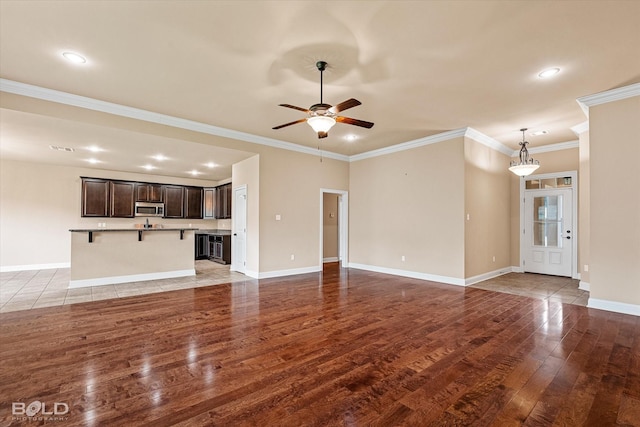 9214 Mykanos Trl, Shreveport, LA 71106 - unfurnished living room with light wood-style floors, a ceiling fan, recessed lighting, ornamental molding, and baseboards