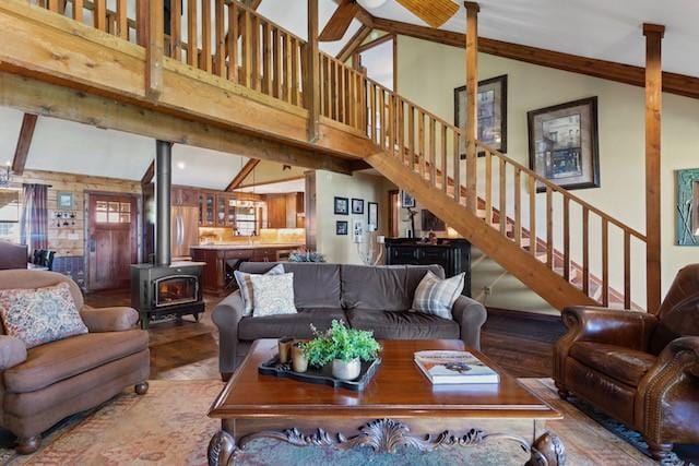 16887 Rainbow Ridge Cir, Tyler, TX 75707 - living room featuring a wood stove, stairs, high vaulted ceiling, wood finished floors, and beamed ceiling