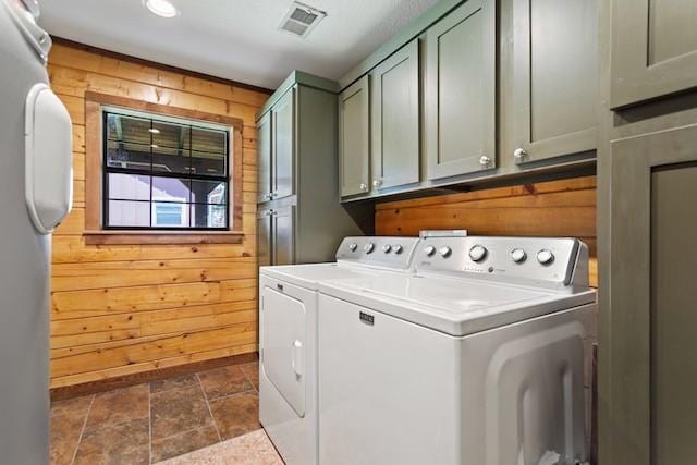 16887 Rainbow Ridge Cir, Tyler, TX 75707 - washroom with separate washer and dryer, wooden walls, cabinet space, and stone finish flooring