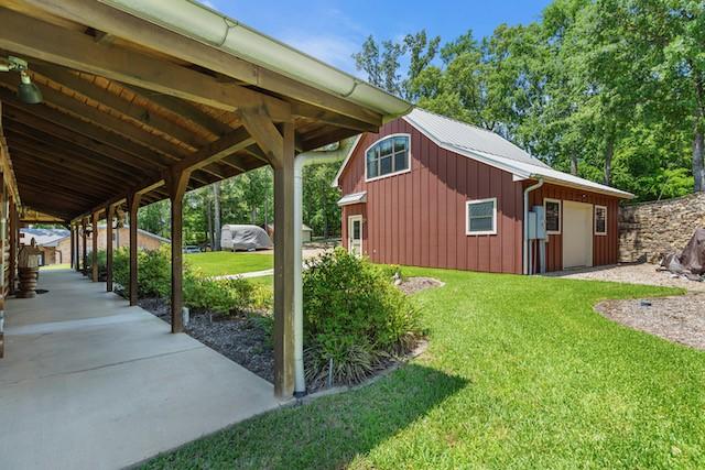 16887 Rainbow Ridge Cir, Tyler, TX 75707 - view of side of property with a garage, a lawn, and board and batten siding