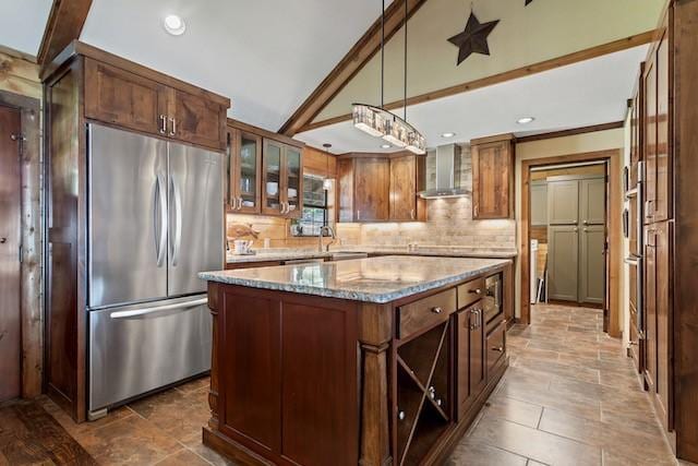 16887 Rainbow Ridge Cir, Tyler, TX 75707 - kitchen with stainless steel refrigerator, wall chimney exhaust hood, tasteful backsplash, a kitchen island, and light stone countertops