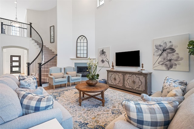 2840 Spring Valley Way, Anna, TX 75409 - living area with a high ceiling, wood finished floors, healthy amount of natural light, stairway, and a brick fireplace