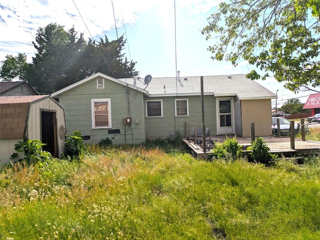 2214 N Woodland St, Amarillo, TX 79107 - rear view of house with a storage unit, a deck, and an outbuilding