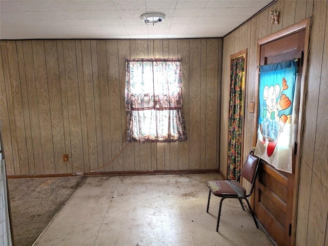 2214 N Woodland St, Amarillo, TX 79107 - spare room with wood walls, baseboards, and unfinished concrete floors