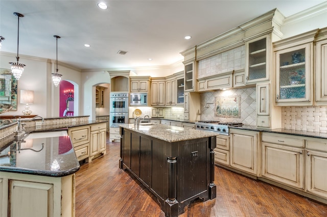 2306 Autumn Run Ct, Cedar Hill, TX 75104 - kitchen featuring cream cabinetry, a large island, appliances with stainless steel finishes, a sink, and crown molding