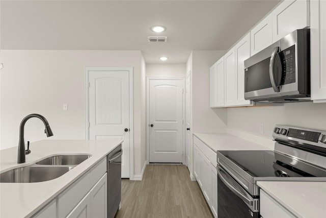 122 Doma Ave, Greenville, TX 75402 - kitchen featuring stainless steel appliances, light wood-type flooring, light countertops, white cabinets, and recessed lighting