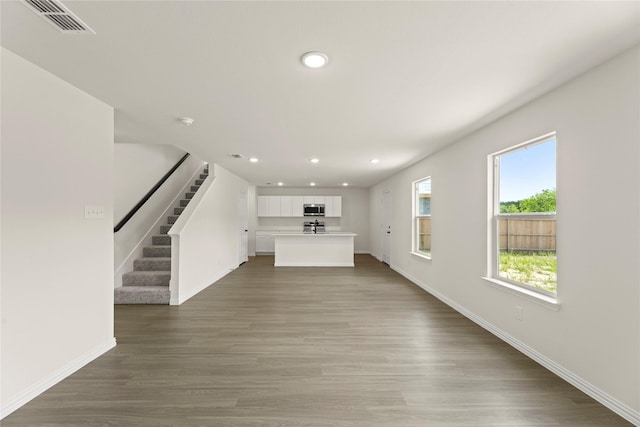 122 Doma Ave, Greenville, TX 75402 - unfurnished living room featuring recessed lighting, stairs, and wood finished floors