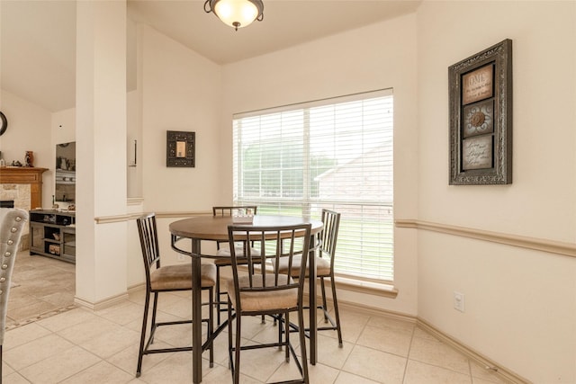 3404 Brookshire Run, Corinth, TX 76210 - dining space featuring light tile patterned flooring, lofted ceiling, baseboards, and a stone fireplace
