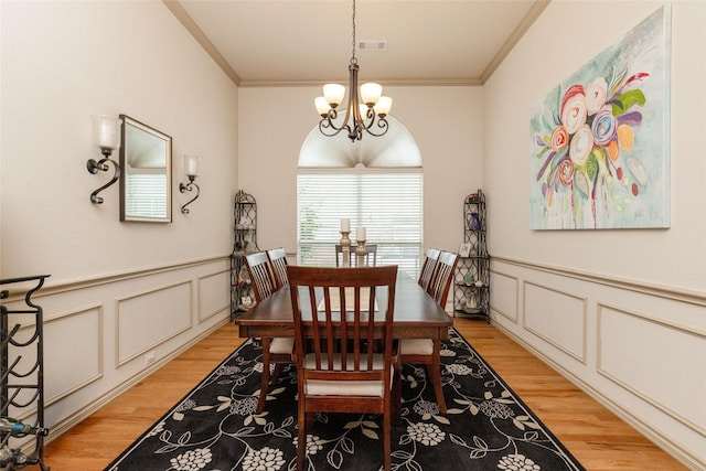 3404 Brookshire Run, Corinth, TX 76210 - dining space with light wood finished floors, a chandelier, crown molding, a decorative wall, and wainscoting